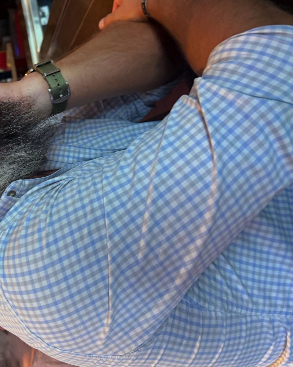Adam Olson wearing glasses and a blue checkered shirt in a restaurant